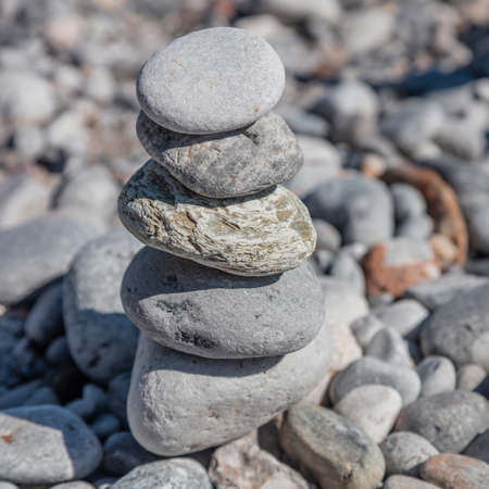 Balance, harmony and peace concept. Zen stones, smooth rock tower stacked on pebble beach background, sunny day. Feng shui, yoga, natural therapyの写真素材