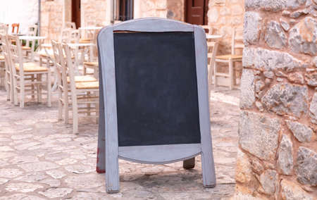 Menu board. Chalkboard blank with wooden frame outdoors on a stone paved sidewalk. Today menu...