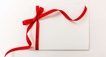 Gift card with red ribbon bow isolated on white background, banner. Empty note paper, copy space,...