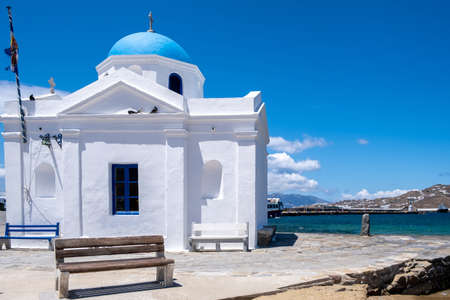 Church with blue dome in Chora town Mykonos island, Cyclades. Greece. White chapel by the sea on clear blue sky background.の写真素材