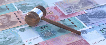 Chinese justice, bribe and corruption concept. Auction judge gavel on China Yuan renminbi bill...