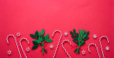 Christmas decoration border on red color background. Felt baubles and candy canes flat lay. Merry Xmas New Year greeting card template, top viewの写真素材