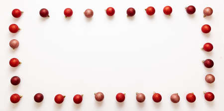 Christmas decoration frame. Xmas red shades balls rectangle border on white background. Baubles greeting card template for New Year Celebration, top view.の写真素材