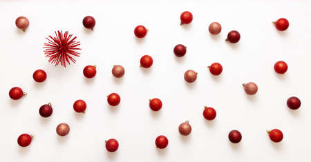Christmas decorations concept. Xmas red shades balls scattered on white background. Small baubles flat lay, greeting card for New Year Celebration, top view.の写真素材