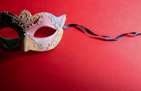 Carnival Venetian mask colorfoul handmade on red color background. Traditional festival disguise, Mardi Gras masqueradeの写真素材