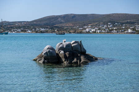 Paros island Cyclades Greece. Granite white rock eroded by sea salt and wind. Kolymbithres village whitewashed buildings background. Calm Aegean sea, blue skyの写真素材