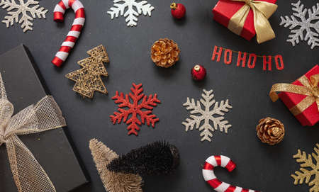 Christmas decoration flat lay on black color background. Gifts, baubles and candy canes, top viewの写真素材