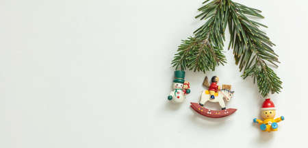 Christmas New Year greeting card template. Wooden vintage toys and fresh fir twig on white color background, copy space.の写真素材