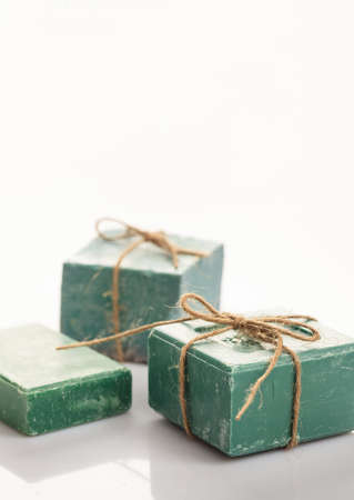 Handmade soap bars tied with rope on white background. Luxury green bath soap from olive...