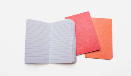 Notepad isolated on white background. Open copybook, blank paper page on red and orange color hardcover notebook, School supply,の写真素材