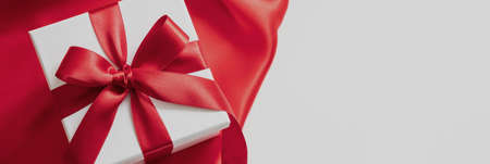 Valentine day gift, Christmas present, curly decoration. Overhead of white box with red ribbon and...