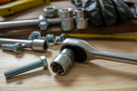 Torque wrench, work tool with reversible ratchets on wooden background. Hand tool for screw and nut...