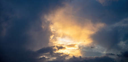 Cumulus cloudscape white grey color and orange shade. Sunset light color the cloudy sky. Twilight,...