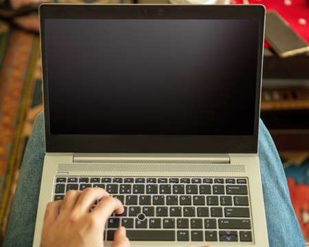Home office work. Empty blank screen, male hand typing on a laptop computer keyboard, open notebook...