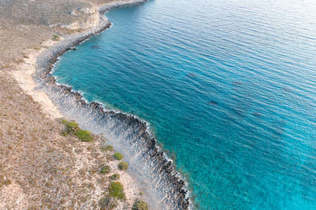 Coastline aerial drone view. Rocky coast, turquoise blue color water, calm sea surface with small ripples. Elafonisos, Greek island, Greeceの写真素材