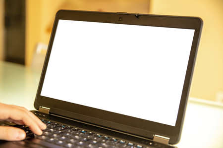 Blank screen laptop computer, home office work. Man type, open notebook on desk, white empty display, copy spaceの写真素材