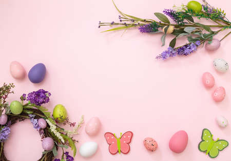 Easter flat lay. Pastel color egg, flower wreath and season decoration on pink background, top view, copy space. Spring Holiday celebrationの写真素材