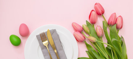 Easter table setting. Pastel color egg and pink tulip flower decoration on pink background, view from above. Spring Holiday celebration.の写真素材