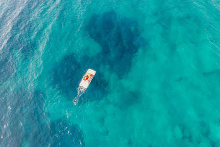 Summer leisure activity, family on a water bike, blue sea water background, aerial drone view. Sunny...
