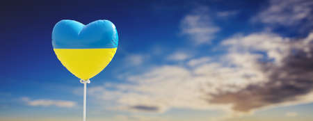 Support Ukraine, stop war, truce and peace. Ukrainian flag heart shape balloon on cloudy sky background, banner, copy space. 3d renderの写真素材