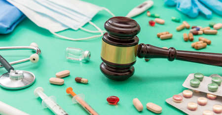 Health Medicine and Law. Judge gavel and medication on green background, close up view. Healthcare Crime and fraud conceptの写真素材