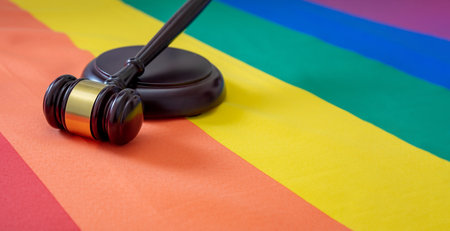 LGBT Law, Gay marriage. Judge gavel on rainbow color flag, close up view. Transgender rights, Copy spaceの写真素材