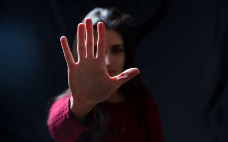 Stop violence against women, sexual abuse, trafficking. Young woman with raised hand for dissuade,...