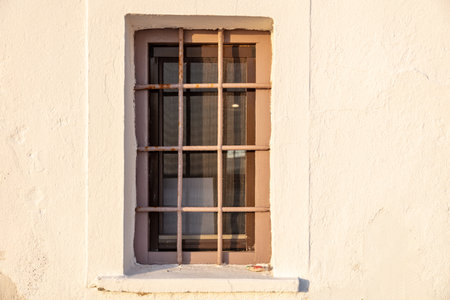Old window and banister metal railing on white wall background. House security, front view....