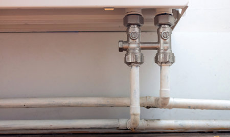 Central heating system concept. Old fashioned stationary cast iron radiator with heating pipe,...