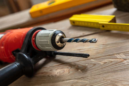 Electric drill tool on carpenter work bench table closeup view. Home repair, diy and fix conceptの写真素材