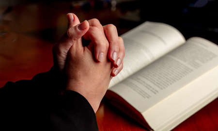 Prayer, woman hands over an open Holy Bible book, wooden desk background. Pray to God, faith,...