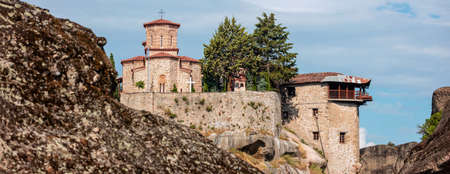 Meteora Greece. Varlaam Holy Monastery buildings on top of rocks, blue cloudy sky, close up view....