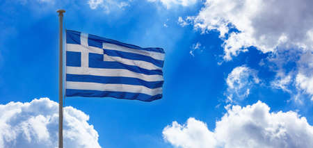 Greek national official flag on flagpole waving in the wind. Greece sign symbol. Blue sky with...