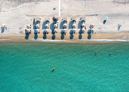 Greece, sandy beach, aerial drone view. People swim and relax at Chalkidiki peninsula. Sunny summer...
