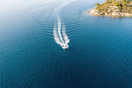 Motorboat, speed boat navigating on rippled sea background, white wake. Summer vacation in Aegean Sea Greece. Aerial drone viewの写真素材