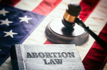 Abortion law in USA concept. Pregnancy termination ban. Judge gavel and Abortion Law book on US...