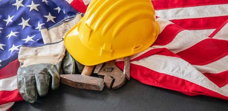 Labor Day concept. American flag and construction tools on dark background, above view. USA holiday celebrationの写真素材