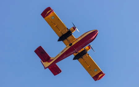 Canadair flight, Amphibious Firefighting Aircraft, Scooper on clear blue sky background. Yellow red...