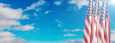 USA flags on poles, blue cloudy sky background, banner. National America Holiday template, copy space. 3d renderの写真素材