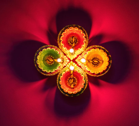 Diwali, Deepavali Hindu Festival of lights celebration. Diya oil lamp lit on red background, top view.の写真素材