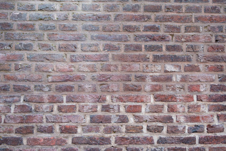 Brickwall background texture. Weathered, aged, grunge, empty brickwork with row of faded red color...