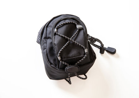 Back to school concept. Black trendy backpack isolated cutout on white background. Overhead view