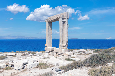 Naxos island, Temple of Apollo, Cyclades Greece. Portara, marble pillars gate, sunny day, calm sea, blue sky background. Summer archeology destination.のeditorial素材