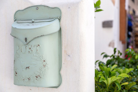 Old rusty metal mailbox on  house wall background. Vintage exterior letterbox, traditional old fashioned design light green postbox.の写真素材