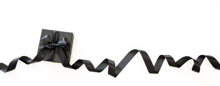 Black Friday Sale banner. Gift box with black curly satin ribbon isolated against white background, copy space, Sale templateの写真素材