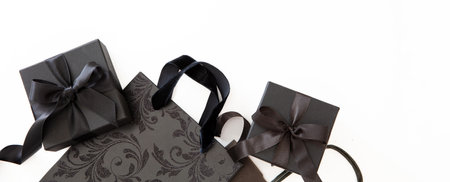Black Friday sale banner. Shopping paper bag and gift box with curly ribbon isolated on white, top view. Copy space, Holiday Sales templateの写真素材