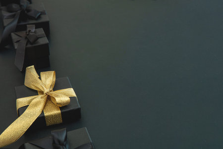 Black Friday Sale and Christmas presents. Good buy, bargain concept. Gift boxes one with gold ribbon, close up view.の写真素材