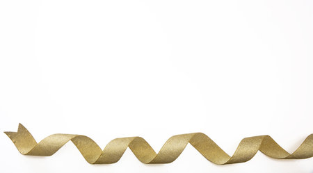 Gold ribbon isolated on white background, Christmas decoration, copy space. Gifts, golden xmas presents shopping and wrap concept.の写真素材