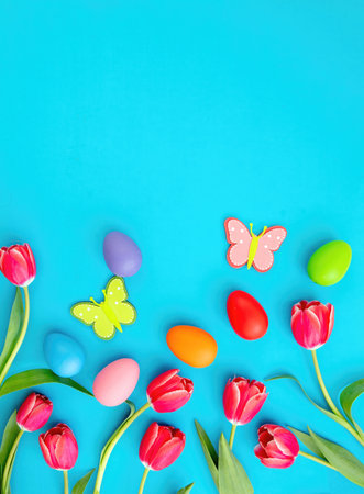 Happy Easter card template, flat lay. Easter egg, tulips and season decoration on blue background, top view, copy space.の写真素材