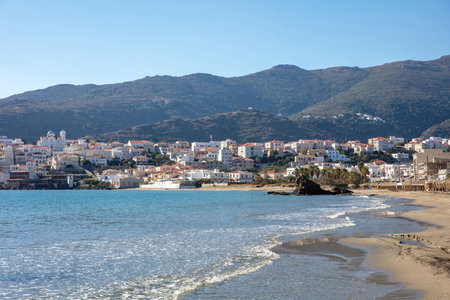 Andros island, Neimporio Beach at Chora town, Cyclades Greece. Seafront building, sandy cosmopolitan beach, sparkle sea, blue sky sunny day.の写真素材